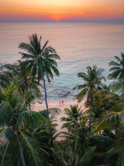 Breathtaking sunset at Takhian Beach in Koh Kood, Thailand with palm trees framing the serene ocean