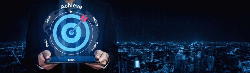 A businessman stands against a night city backdrop, displaying a dart hitting a target, symbolizing achievement, success, and strategic goal completion in business. Gantry © InfiniteFlow