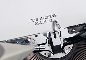 Typewriter text saying this machine beats ai on paper symbolizing human creativity versus artificial intelligence or tradition versus progress.