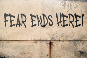 Fear ends here message on concrete wall