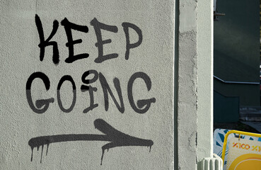 Keep Going message graffiti painted on urban wall