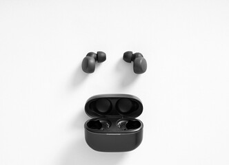 Black wireless earbuds and charging case on white background