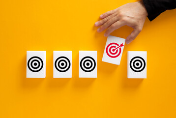 Hand picking red target card among black goals. Goal selection.