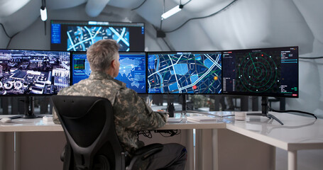 Military Officer Monitoring Surveillance Data On Desktop Computer