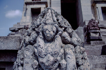 Ancient stone statue of a deity with multiple heads in a temple setting