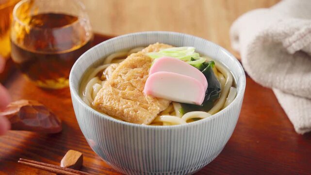 大きな油揚げにかまぼこを添えたきつねうどん