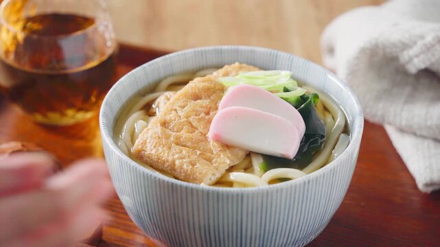 大きな油揚げにかまぼこを添えたきつねうどん