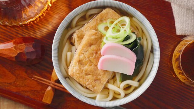 大きな油揚げにかまぼこを添えたきつねうどん