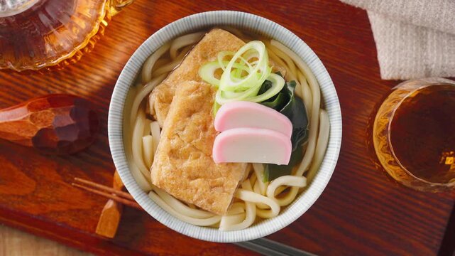 大きな油揚げにかまぼこを添えたきつねうどん