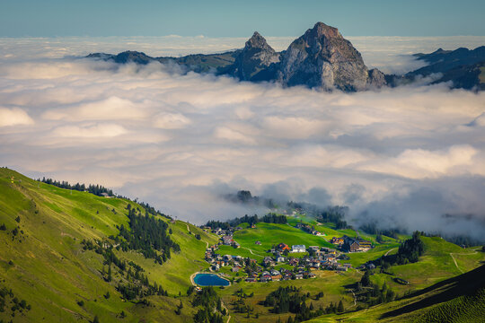 Green fields above the misty valley, Stoos village, Switzerland