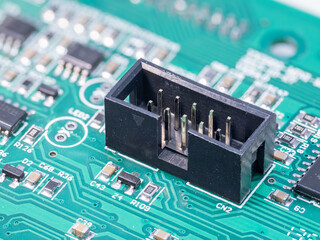 Square male connector on a green printed circuit board.
