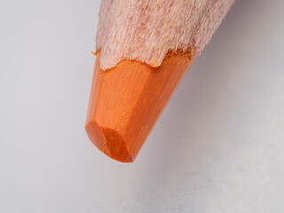 Macro view of a sharpened orange crayon.