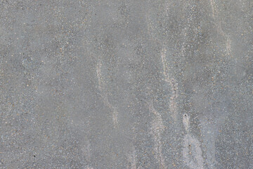 A grey concrete wall damaged by time and weather.