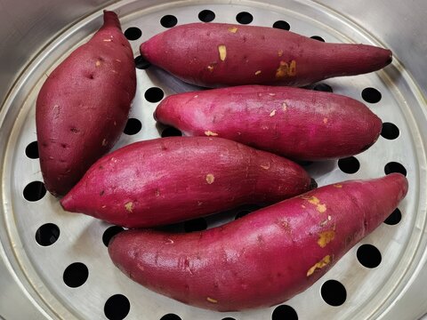 Fresh Purple Sweet Potatoes Prepared in a Metal Steamer Pot for Healthy Cooking