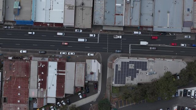 Drone video capturing a busy urban street in Melbourne. Overhead view of moving cars, buildings, and rooftops. Vibrant city life captured in a clear, static aerial shot.