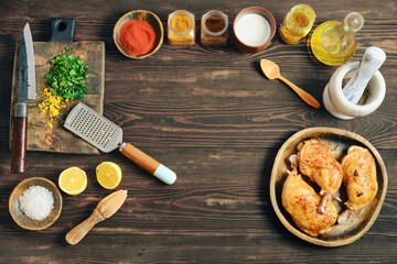Cooking chicken with herbs and spices on a wooden table in a home kitchen
