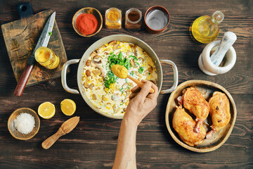 Cooking a dish using spices, chicken, and fresh ingredients at home in the kitchen
