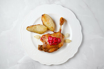 Enjoying duck confit served with roasted potatoes and sauce in a simple dining setup