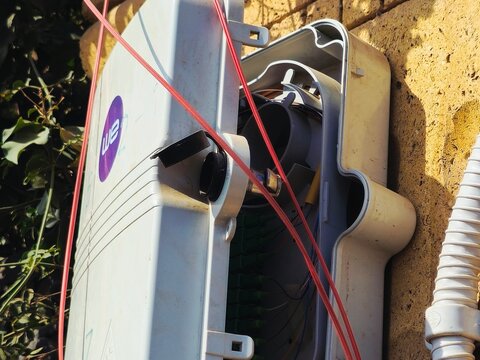 Giza, Egypt, February 4 2026: A closeup of a WE outdoor fiber optic terminal box, Network interface device NID, Optical Network Terminal ONT, used to connect fiber internet service to a building