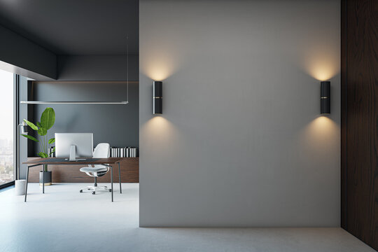 Blank wall in modern office interior with desktop and natural light, ideal for poster, logo or design mockup placement with clean concept. 3D Rendering