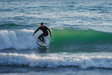 Surfer ride a clean green wave, aquatic water sport in the ocean.