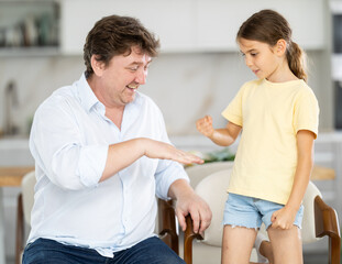 Fototapeta premium Father and little daughter playing rock paper scissors game
