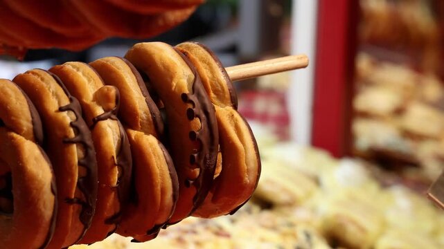 Chocolate covered donuts in pretzel shape on a food market