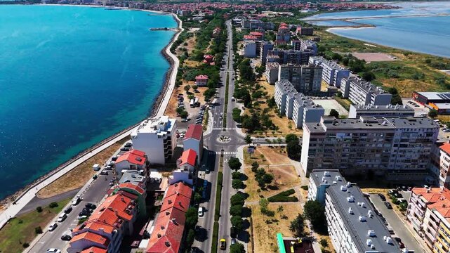 Top-down drone view of a main Pomorie road with sea visible on both sides, revealing the peninsula-like shape of the town.