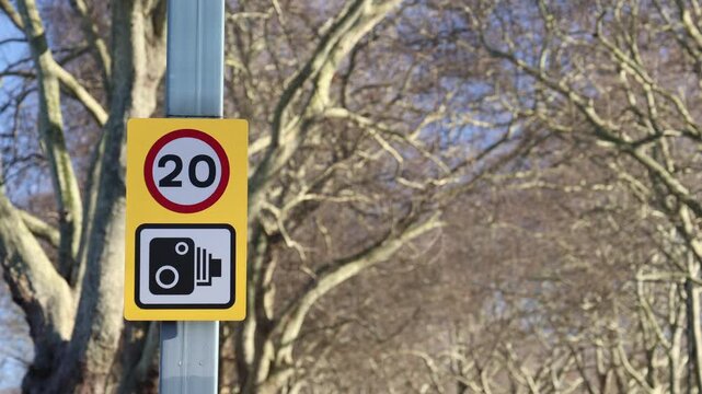 Speed limit and traffic camera sign, establisher blurred background