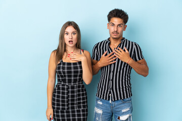 Naklejka premium Teenager caucasian couple isolated on blue background surprised and shocked while looking right
