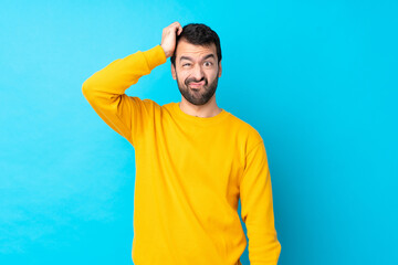 Naklejka premium Young caucasian man over isolated blue background with an expression of frustration and not understanding