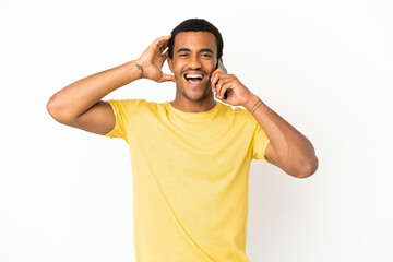 Fototapeta premium African American handsome man using mobile phone over isolated white background with surprise expression