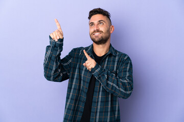 Naklejka premium Caucasian man isolated on purple background pointing with the index finger a great idea