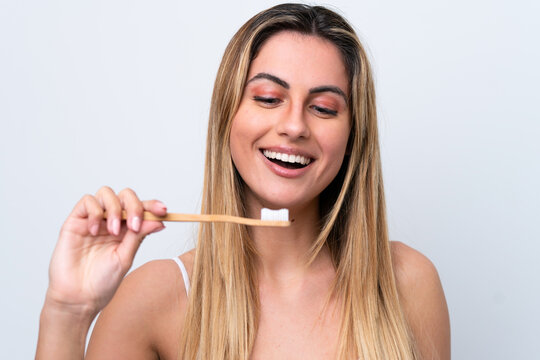 Young caucasian woman isolated on white background with a toothbrush