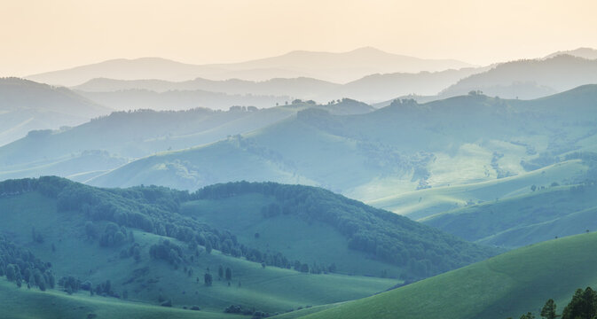 Ridge gradients in haze, view of the summer evening, hills and mountain slopes in sunset light