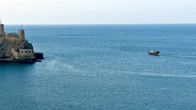 Traditional Omani boat sailing off Mutrah beach in Muscat, reflecting maritime heritage and Arabian Sea beauty.