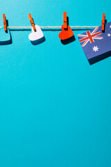 Australia flag and heart shapes hanging on clothesline with copy space over blue background