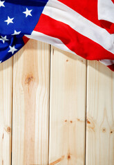 Overhead view of red and white stripes along with stars on america flag over wooden table