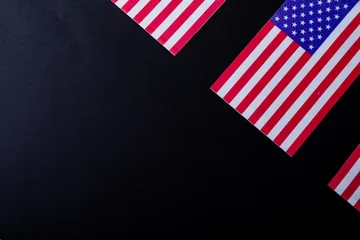 Fotobehang Vlees Overhead view of america flags with red and white stripes along with stars over black background  © wavebreak3