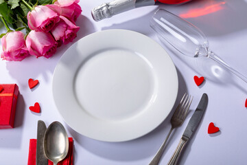 Fresh pink roses and place setting on white background, copy space