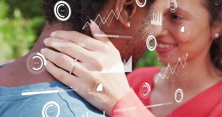 Embracing couple with left hand on neck in park, showing ring, HUD, wearing blue and red