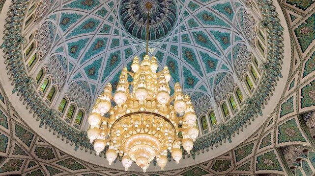 Interior view of Sultan Qaboos Mosque in Muscat, featuring elegant Islamic patterns, grand chandelier, and Omani design.
