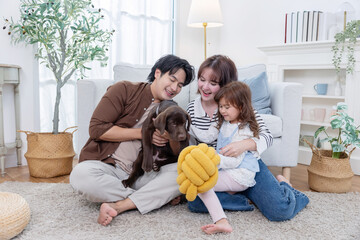 Family plays with dog at home during the day in a cozy living room
