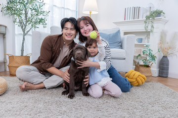 Family plays with dog at home during the day in a cozy living room