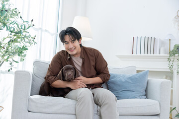 A man enjoys time with labrador retriever dog in their living room