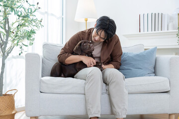 A man enjoys time with labrador retriever dog in their living room