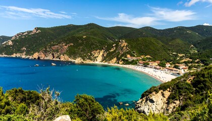 Obraz premium A stunning coastal panorama reveals a turquoise bay embraced by lush green hills. A sandy beach lines the coast where buildings are dotted