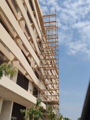 Scaffolding has been erected at front balcony of high rise residential building. Safety scaffolding covers the front of single-story building, providing protection process to ensuring worker safety © Usama