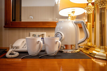 Hospitality tea tray with kettle and cups on table