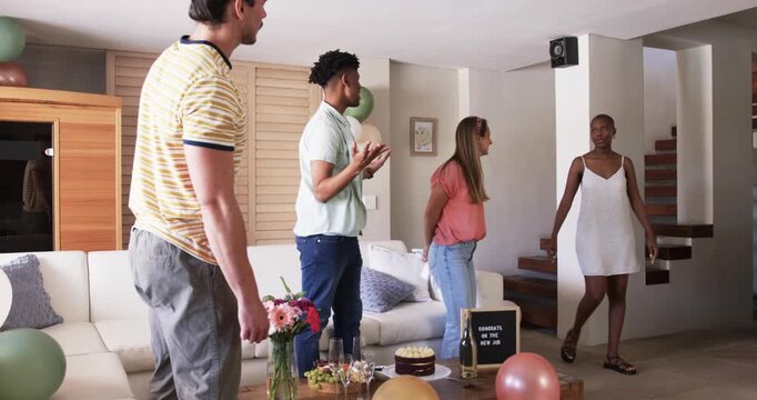 Friends celebrating new job at home, dancing and smiling with joy
